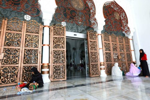 Four Aceh women sit outside a mosque after performing Dhuhur ritual prayers in Baiturahman mosque, Nanggroe Aceh Darusallam, Wednesday, May 25. (The Jakarta Post/Wienda Parwitasari)